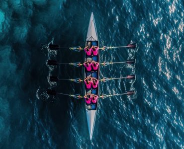 Rowing team in a boat sports water surface.