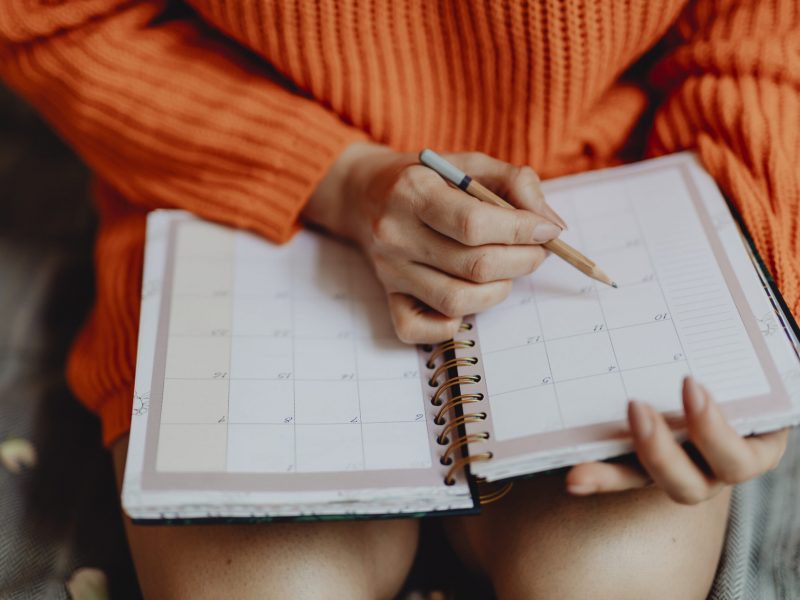 Woman writing on her daily planner