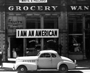Oakland, Calif., Mar. 1942. A large sign reading "I am an American" placed in the window of a store, at [401 - 403 Eighth] and Franklin streets, on December 8, the day after Pearl Harbor. The store was closed following orders to persons of Japanese descent to evacuate from certain West Coast areas. The owner, a University of California graduate, will be housed with hundreds of evacuees in War Relocation Authority centers for the duration of the war by Dorothea Lange.More: View public domain image source here