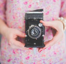 Photo- Vintage Camera Woman holding vintage analog film camera. Visit Kaboompics for more free images.